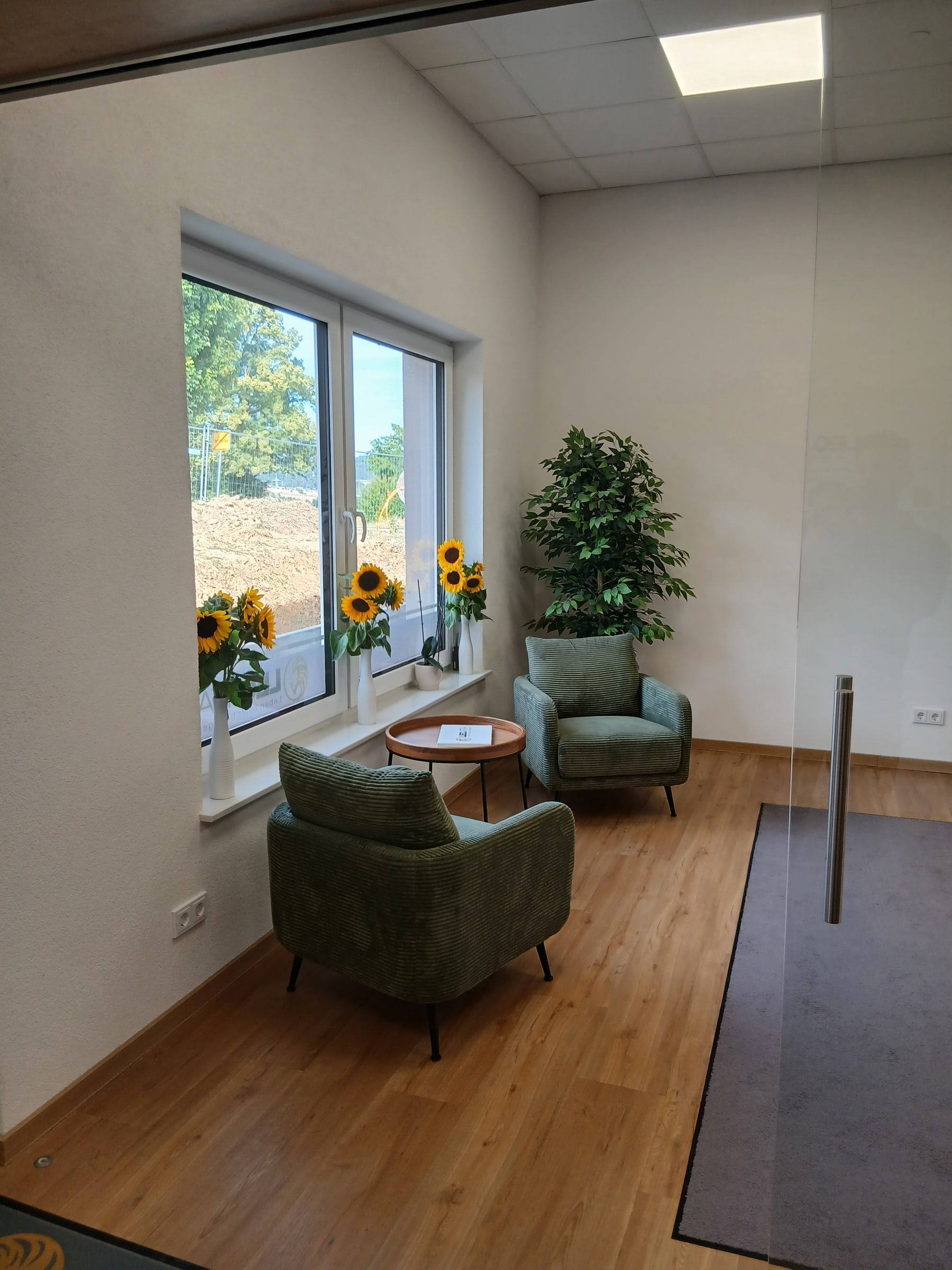 Sitzbereich mit grünen Sesseln am Fenster